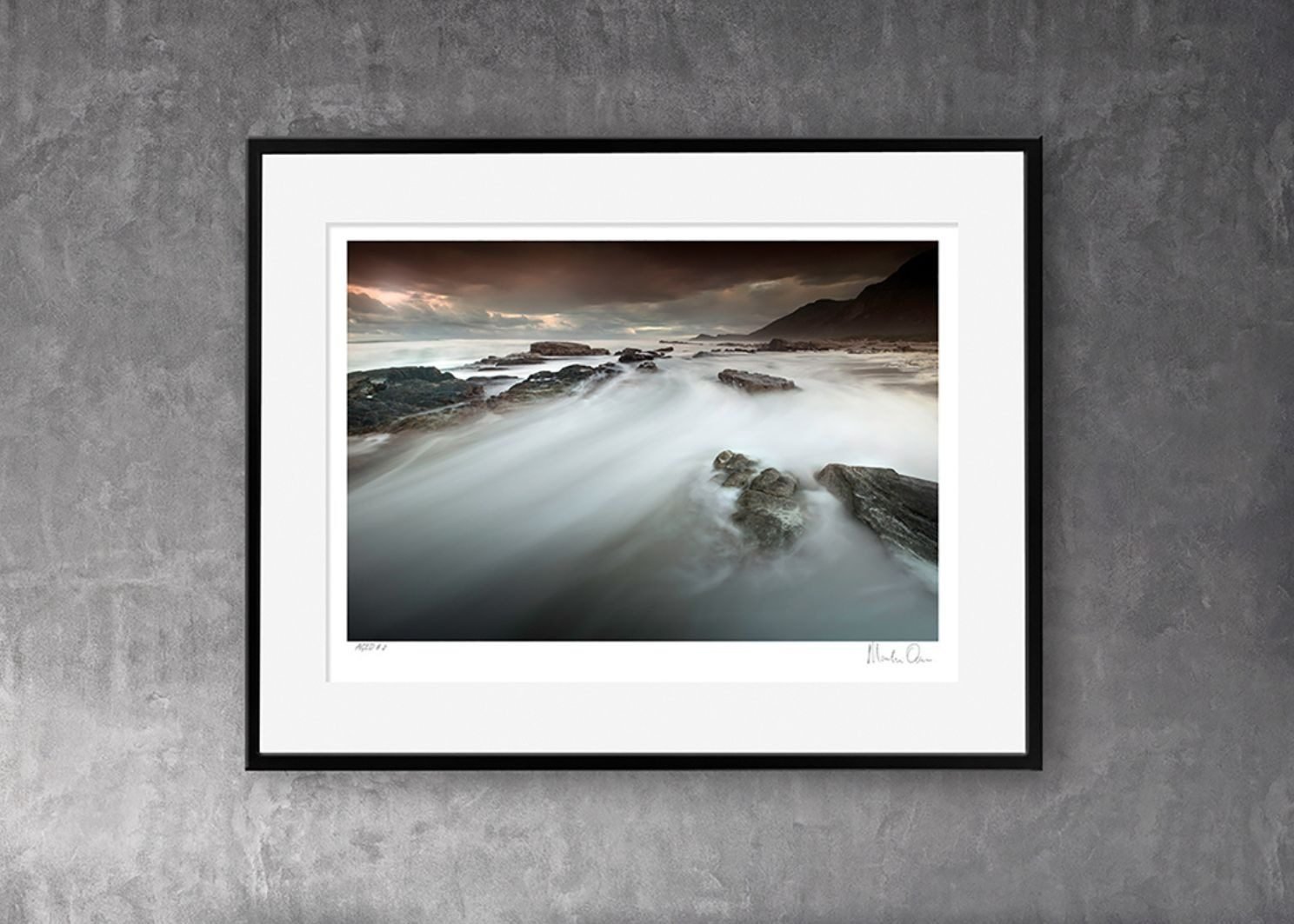 A long exposure landscape in a black frame with a white mount