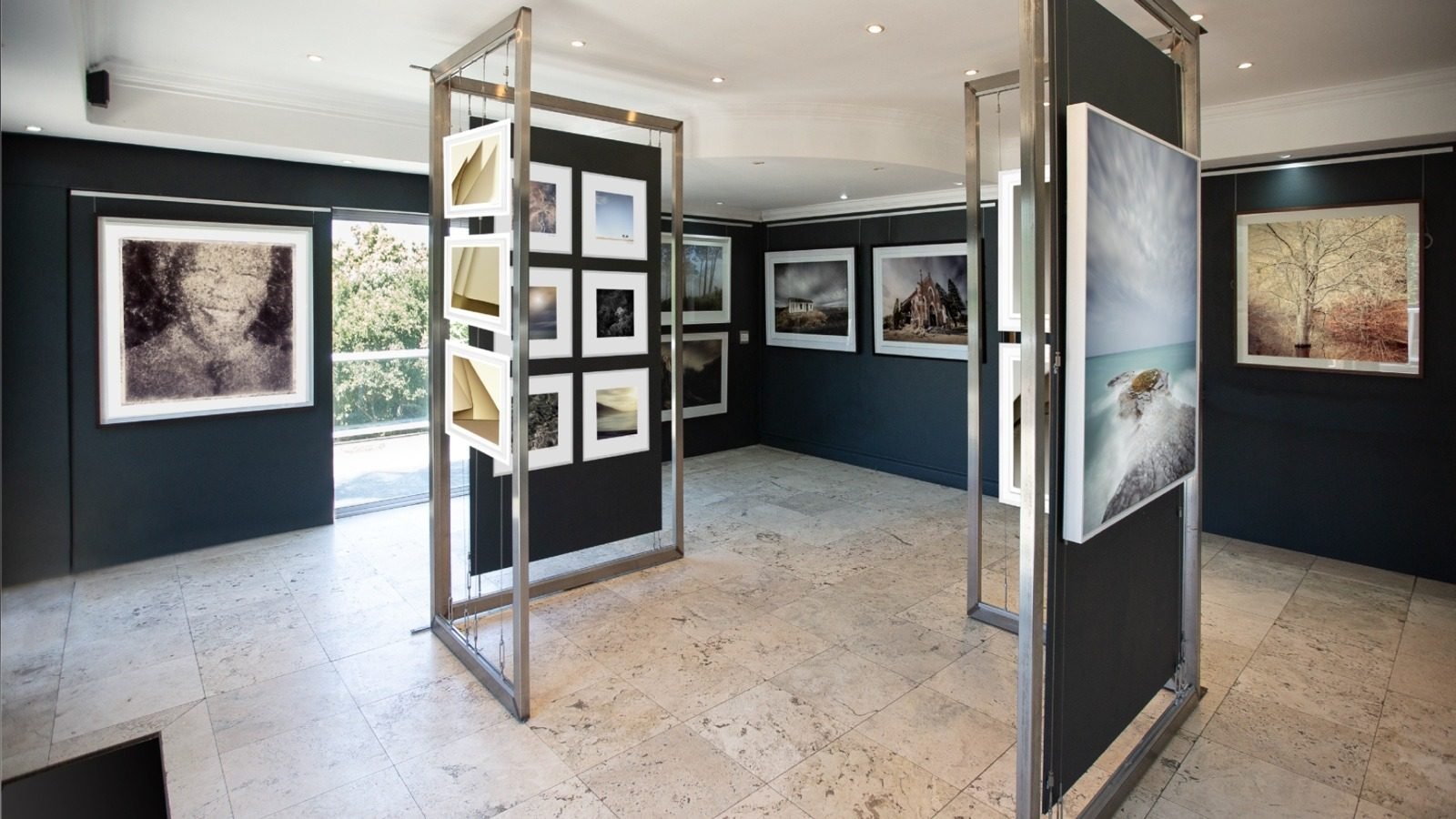 An exhibition room at Osner Gallery in Hout Bay with framed photographs on stands and walls