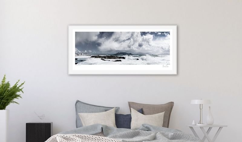 Seascape panorama in a white frame above a bed