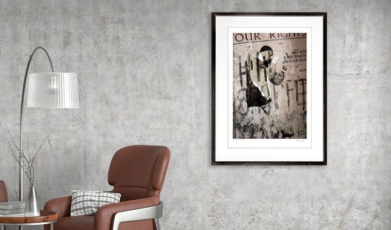 Street collage in a black frame beside a reading lamp