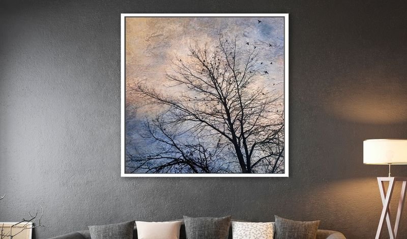 Bare tree against an evening sky on a charcoal wall